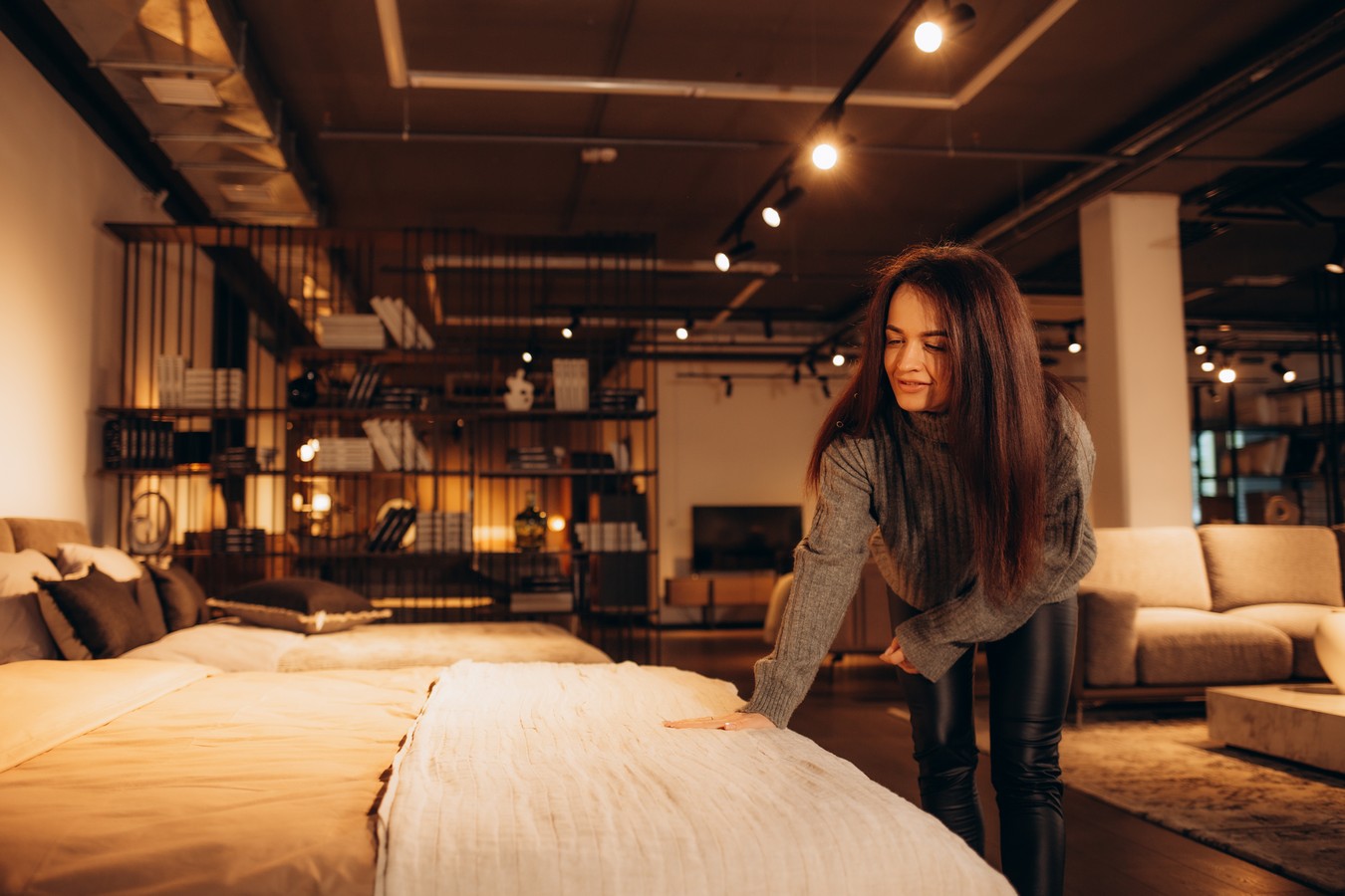 woman lying on bed with orthopedic pillow in furniture store